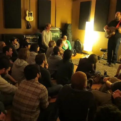 A house show, with the crowd sitting on the live room floor, 2011