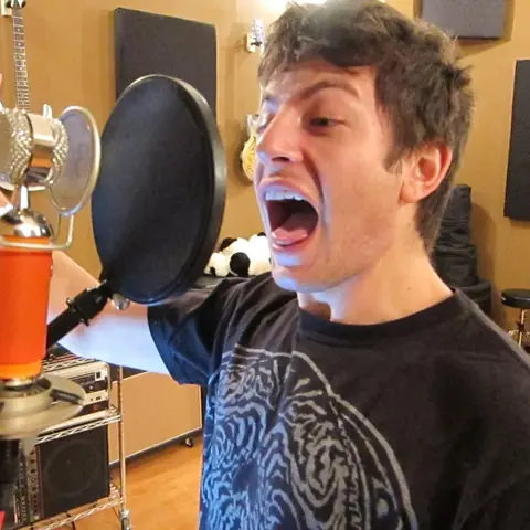 A singer belting into the mic and pointing at the sky, 2011